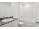 Clean bathroom with tub, granite countertop sink, and tiled walls, offering a modern aesthetic at 1542 Mermaid Way, Haines City, FL 33844