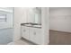 Bright bathroom featuring double sinks with granite counters and white cabinets, with a view to bedroom and closet at 1542 Mermaid Way, Haines City, FL 33844