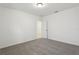 This bedroom features neutral carpet, white walls and trim, and a door leading to another room at 1542 Mermaid Way, Haines City, FL 33844