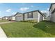Well-kept lawn surrounds a one-story home with brick accents and a gray exterior at 1542 Mermaid Way, Haines City, FL 33844