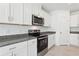 Bright kitchen with white cabinets, stainless steel appliances, and granite countertops at 1542 Mermaid Way, Haines City, FL 33844