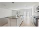 Open kitchen and living area with an island, stainless steel appliances, and tile flooring at 1542 Mermaid Way, Haines City, FL 33844