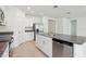 The open kitchen features white cabinetry, an island, and stainless steel appliances at 1542 Mermaid Way, Haines City, FL 33844