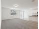 Bright living area with carpet, a sliding glass door, and a view of the modern kitchen at 1542 Mermaid Way, Haines City, FL 33844