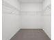 Spacious walk-in closet with shelving and carpeted floor at 1542 Mermaid Way, Haines City, FL 33844