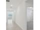 Bright hallway with tile flooring leads to carpeted bedrooms and a well-lit living space at 3824 Giorgio Dr, Winter Haven, FL 33884