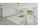 Modern kitchen features a stainless steel sink on an island with a view into an open, sun-filled room at 3824 Giorgio Dr, Winter Haven, FL 33884