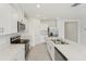 Bright kitchen featuring modern stainless steel appliances, a quartz island countertop, and ample cabinet space at 3824 Giorgio Dr, Winter Haven, FL 33884