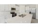 Well-lit kitchen featuring a stainless steel refrigerator, appliances, and a sink in a quartz countertop kitchen island at 3824 Giorgio Dr, Winter Haven, FL 33884