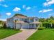 Charming two-story home with a three-car garage, manicured lawn, and a brick driveway at 708 Fox Edge Ct, Oviedo, FL 32765