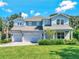 Elegant two-story home featuring a three-car garage, well-kept lawn, and a paved driveway at 708 Fox Edge Ct, Oviedo, FL 32765