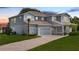 Attractive two-story home featuring a three-car garage, landscaped lawn, and a brick driveway at 708 Fox Edge Ct, Oviedo, FL 32765