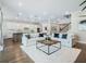 Bright living room with hardwood floors, plush white couches, and a modern kitchen in the background at 708 Fox Edge Ct, Oviedo, FL 32765