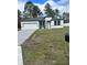 Newly built home with gray and white exterior, paved driveway, and grassy lawn at 6807 Sw 153Rd Place Rd # 6807, Ocala, FL 34473