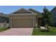 Charming single-story home features a brick driveway, attached two-car garage, and well-maintained landscaping at 1926 Church Lake St, Groveland, FL 34736
