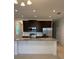 Modern kitchen featuring granite countertops, dark wood cabinets, and stainless steel appliances at 1926 Church Lake St, Groveland, FL 34736