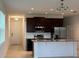 Open-concept kitchen boasts stainless steel appliances, dark wood cabinetry, and a breakfast bar at 1926 Church Lake St, Groveland, FL 34736