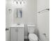 Bathroom with a white vanity, toilet, and a simple mirror at 610 Walker St, Holly Hill, FL 32117
