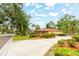 Aerial view of a well-maintained home with lush landscaping, a long driveway, and a charming brick exterior at 1546 Stormway Ct, Apopka, FL 32712