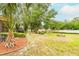 Spacious backyard with mature trees and lush lawn, complemented by a charming patio area for outdoor enjoyment at 1546 Stormway Ct, Apopka, FL 32712