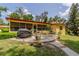 Back patio with BBQ grill surrounded by lush landscaping and brick-lined walkway at 1546 Stormway Ct, Apopka, FL 32712
