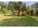 Large backyard featuring mature trees, a lush lawn, and a patio with furniture at 1546 Stormway Ct, Apopka, FL 32712