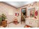 Charming bathroom featuring patterned wallpaper, dual sinks, and ample natural light for a welcoming space at 1546 Stormway Ct, Apopka, FL 32712