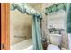 Bathroom features a tiled wall, bathtub, shower curtain, floral wallpaper, and vanity with floral arrangement at 1546 Stormway Ct, Apopka, FL 32712