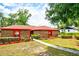 Inviting brick home with a red roof, lush green landscaping, and a concrete walkway leading to the front door at 1546 Stormway Ct, Apopka, FL 32712
