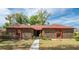 Charming brick home with red trim featuring a well-manicured lawn and a paved walkway leading to the front entrance at 1546 Stormway Ct, Apopka, FL 32712