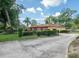 View of the home's side, showing the two car garage and mature landscaping at 1546 Stormway Ct, Apopka, FL 32712