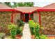 Inviting front entrance showcases the brickwork and red trim, framed by meticulously maintained landscaping and a pathway at 1546 Stormway Ct, Apopka, FL 32712