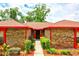 Charming front entrance with brick facade, complemented by red trim and neatly trimmed greenery leading to the doorway at 1546 Stormway Ct, Apopka, FL 32712