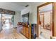 Hallway view reveals a transition space with laminate floors, leading to a sunroom and a charming bathroom at 1546 Stormway Ct, Apopka, FL 32712