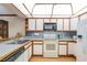 Well-lit kitchen featuring wood-trimmed cabinets, neutral countertops, updated appliances, and wood flooring at 1546 Stormway Ct, Apopka, FL 32712