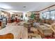 Open living room that flows into the sun room with lots of furniture at 1546 Stormway Ct, Apopka, FL 32712