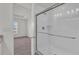 Bathroom featuring a tiled shower with glass doors and a view into the carpeted bedroom at 3409 Narrows Dr, Lakeland, FL 33810