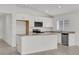 Modern kitchen showcasing white cabinetry, stainless steel microwave, granite counters, and tile flooring at 3409 Narrows Dr, Lakeland, FL 33810