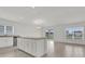 Kitchen island with granite countertops, white cabinetry, and an open view of the backyard through sliding glass doors at 3409 Narrows Dr, Lakeland, FL 33810
