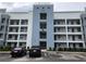 Modern condo building featuring balconies, blue accents, and ample parking for residents and guests at 3161 Paradox Cir # 202, Kissimmee, FL 34746