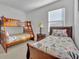 Cozy bedroom featuring a bunk bed and a twin bed with bright, patterned bedding and a window for natural light at 7001 Oakwood St, Davenport, FL 33837