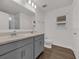 Bathroom with double sink vanity, large mirror, and wood-look floors at 8560 Caribbean Pine Way, Lakeland, FL 33809