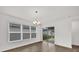 Dining area with large windows, modern chandelier, and sliding door access to the backyard at 8560 Caribbean Pine Way, Lakeland, FL 33809