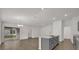 Open-concept living area with modern kitchen, dining chandelier, and sliding door access to the patio at 8560 Caribbean Pine Way, Lakeland, FL 33809