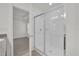 Bright bathroom featuring glass shower door and tile surround; entrance to a bedroom at 8645 Caribbean Pine Way, Lakeland, FL 33809