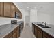 Kitchen showcasing stainless steel appliances, dark wood cabinets and gray granite countertops at 8645 Caribbean Pine Way, Lakeland, FL 33809