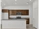 Close up on kitchen featuring dark wood cabinets, granite countertops, and stainless steel appliances at 8645 Caribbean Pine Way, Lakeland, FL 33809