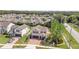 Aerial view of the property showcasing its landscaping, brick driveway, and neighborhood at 5200 Landmark Dr, St Cloud, FL 34771