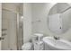Bright bathroom featuring a glass enclosed shower, commode, and sink with an oval mirror at 5200 Landmark Dr, St Cloud, FL 34771