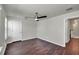 Bright bedroom with ceiling fan, dark flooring and door to hallway at 5200 Landmark Dr, Saint Cloud, FL 34771